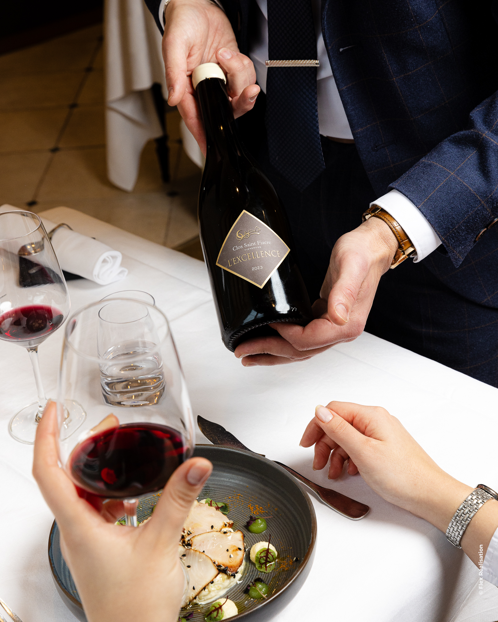 Elegant glass of red wine placed on a green table with dim ambient lighting.